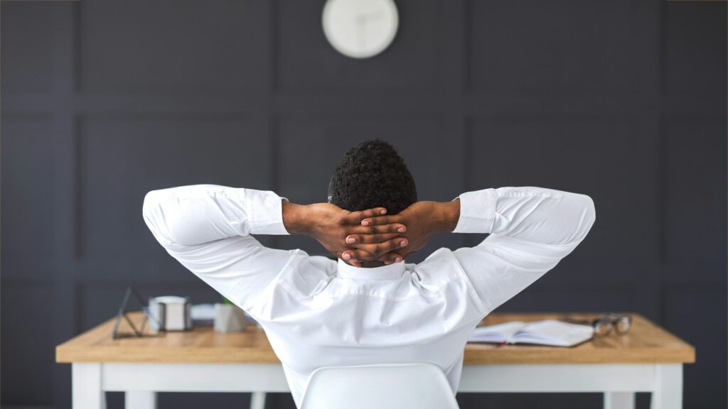 Rear view of african employee relaxing in office